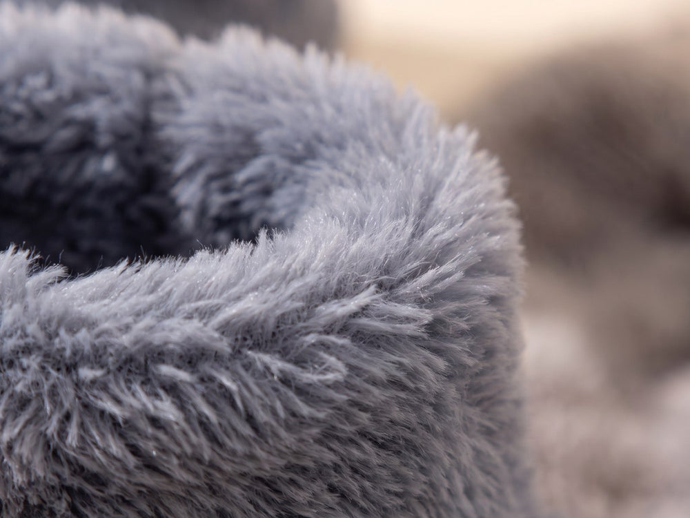 Närbild på den fluffiga grå korallfleecen vid tofflans kant